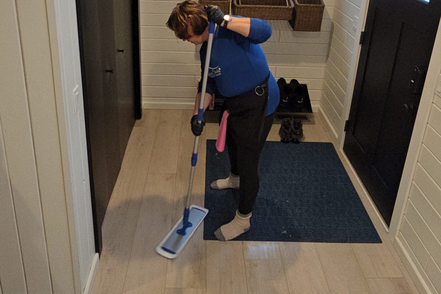 Harbor Shores cleaner mopping an entryway floor with a flat microfiber mop